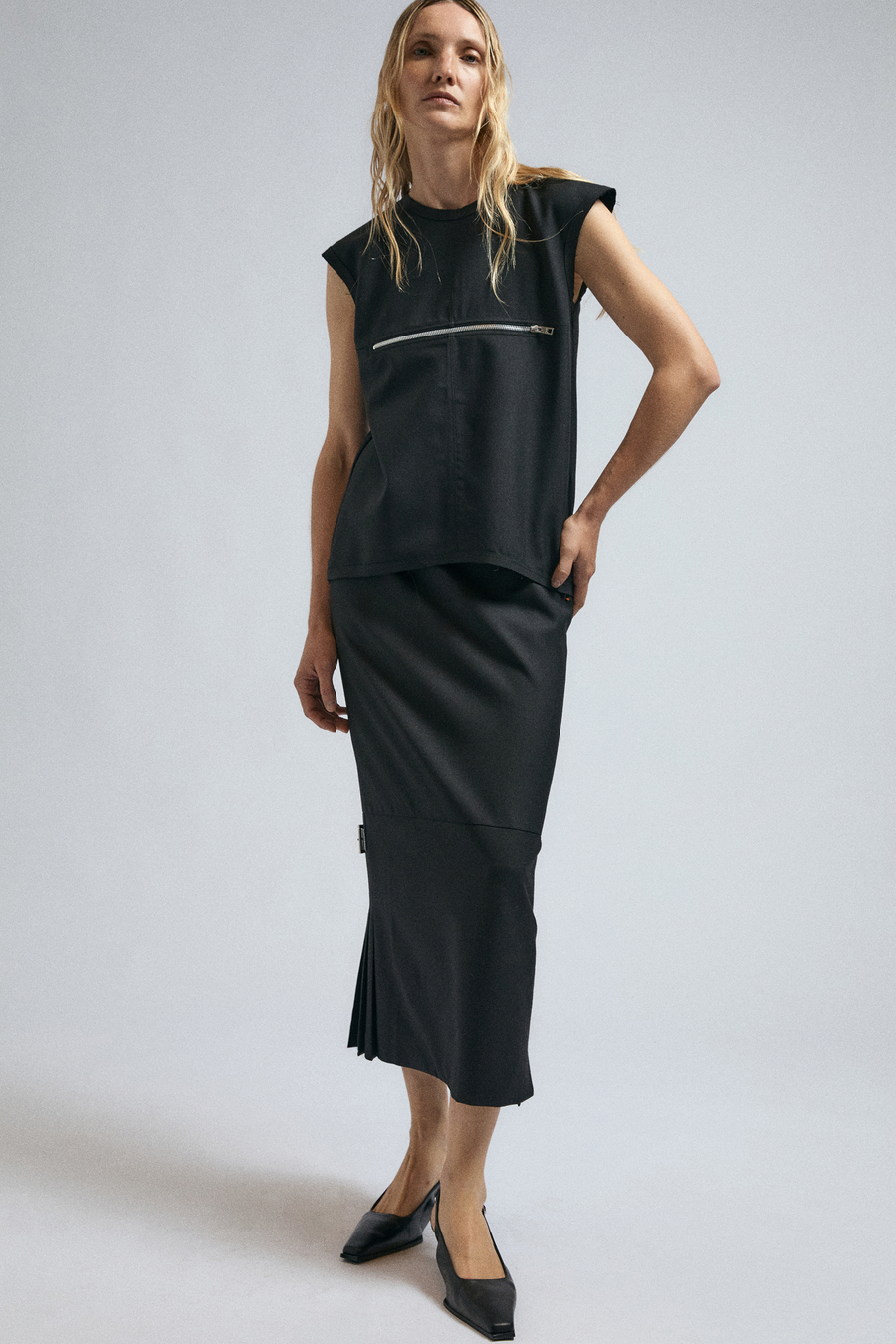 Woman wears the JordanLuca FW24 Black Blowoff Top, paired with the Black Convex Skirt.