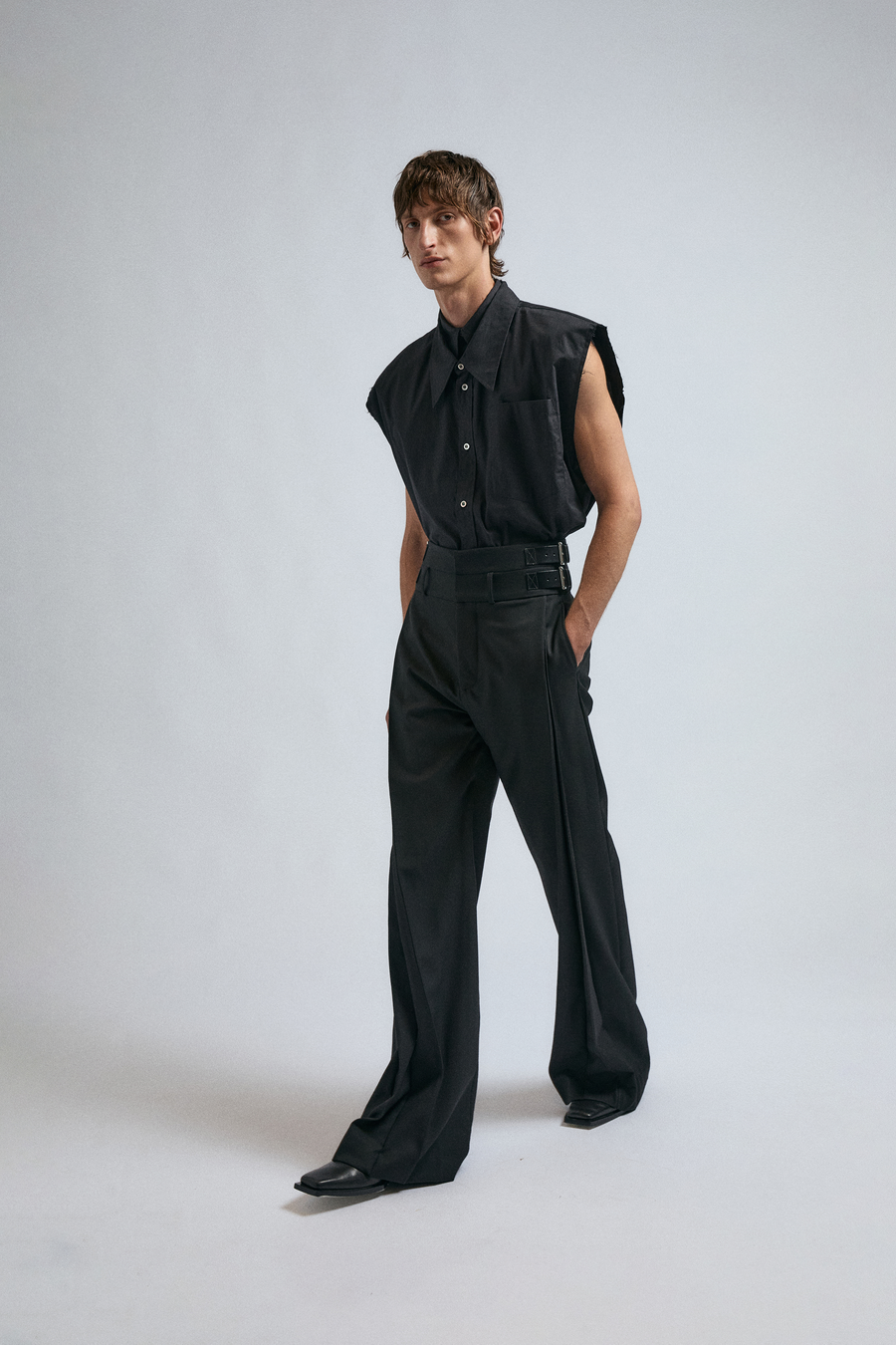 Man wears the JordanLuca FW24 Black Ignition Trousers, paired with a Black Sleeveless Clover shirt.