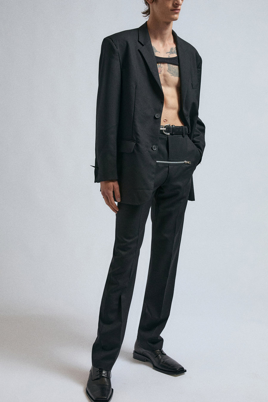 Man wears JordanLuca black Robin trousers, paired with Morgana blazer, black Iggy top and the plain Black Ritz belt.