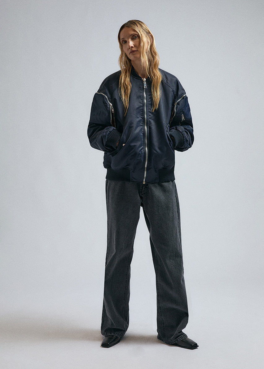 Woman wears JordanLuca FW24 Navy Bulldog bomber, with metal zip details.