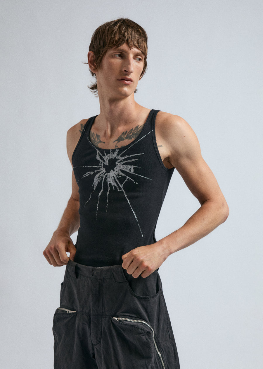 Man wears the black JordanLuca Shatter Tank Top, paired with the Voyage Cargo Trousers.